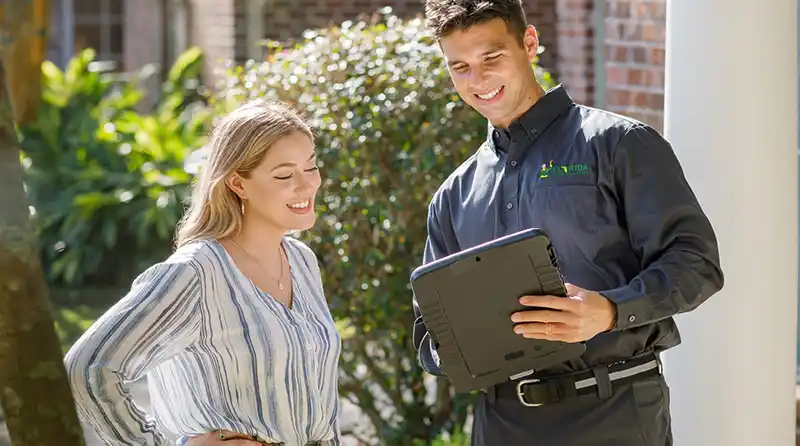 Technician speaking with a home owner in the front yard