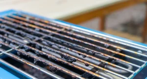 Dirty black mark burned on grilled above blue electric stove from oil or fat pork roasted grilled.