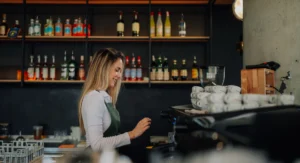 Young barista woman skillfully preparing coffee with a professional machine in a bustling cafe, radiating joy and expertise