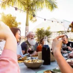 happy family having dinner outside during sunset