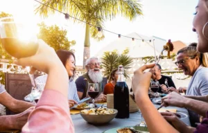 happy family having dinner outside during sunset