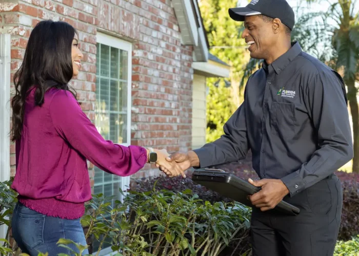 fla colleague shaking hand of customer in front of home