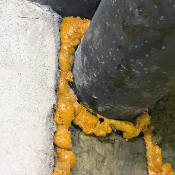 Expansion foam blocking off gaps around a pipe entering a home so rodents can’t get through
